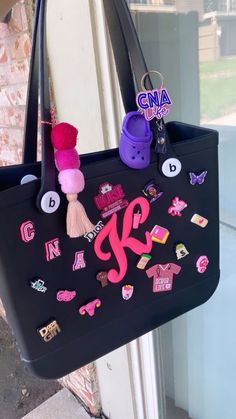 a black bag with pink and purple accessories hanging from it's side window sill