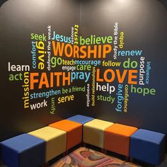 a colorful bench in front of a black wall with words written all over the place