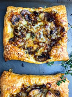 two square pizzas sitting on top of a metal pan covered in cheese and mushrooms