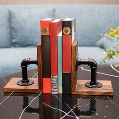 two bookends made out of books sit on a table in front of a couch