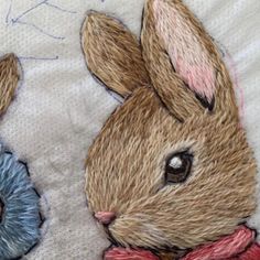 two hand embroidered rabbits on a white blanket