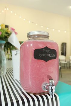 a pink beverage in a jar sitting on top of a table