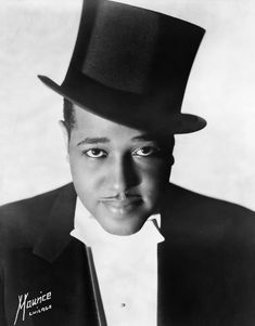 a black and white photo of a man wearing a top hat