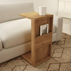 a white couch sitting next to a wooden table on top of a carpeted floor