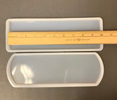 a plastic container with a ruler on top of it