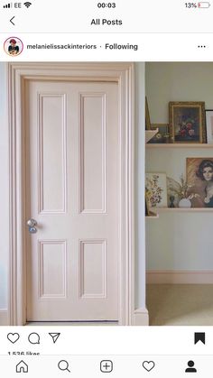 an open door in a room with pictures on the wall and shelves above it,