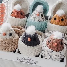 there are many knitted birds in baskets on the table, one is white and the other is brown