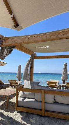 an outdoor seating area with umbrellas on the beach