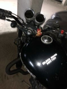 a close up view of the handlebars on a black motorcycle parked in a garage