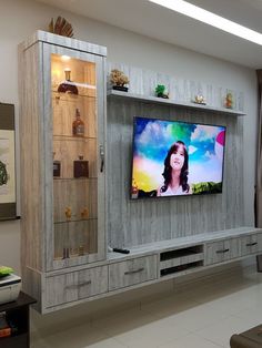 a flat screen tv sitting on top of a wooden entertainment center in a living room