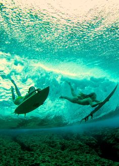 two people are surfing in the ocean on their surfboards and one is falling off his board