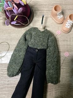 a pair of baby shoes and sweater on a table