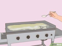 a person is holding a spoon over an outdoor grill with food on the burners