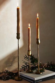 three candles are sitting on top of a book