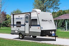 an rv parked on the side of a road next to a picnic area and pavilion