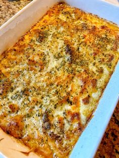 a casserole dish with cheese and herbs in it on a counter top,