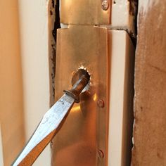 a close up of a door handle with a knife stuck in it