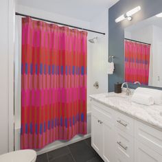 a bathroom with pink and blue shower curtain next to a white sink under a mirror