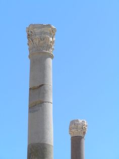 two stone pillars with carvings on them against a blue sky