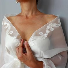 Enhance your bridal ensemble with this stunning ivory-ecru organza shawl stole, adorned with shiny lace trims. The elegant, see-through mesh design drapes effortlessly over the shoulders, offering a romantic touch. Featuring a convenient hands-free loop, the shawl allows for secure styling as the extremity passes through, keeping it perfectly in place. Ideal for brides seeking a lightweight, sophisticated wedding cover-up that blends beauty and practicality. It comes in two length options: Size S: 18.5" x 57.5" (47 x 146 cm) - Suitable for those with an upper body (chest + arms) circumference up to 45.3" (- cm). Size L: 18.5" x 68.5" (47 x 174 cm) - Suitable for those with an upper body (chest + arms) circumference up to 54.3" (- cm)." * As a reference; the model seen at the picture, is in Lace Wedding Shawl, Cream Wedding Dress For Mother Of The Bride, Elegant Wedding Dress With Sheer Dupatta, Elegant Bridal Veil, Elegant Fitted Wedding Dress With Sheer Dupatta, Elegant Wedding Dress With Sheer Dupatta For Ceremony, Elegant White Organza Wedding Dress, Fitted Lace Shawl For Wedding, Elegant Organza Wedding Dress For Ceremony