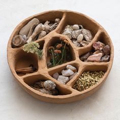 a bowl filled with rocks and plants on top of a table