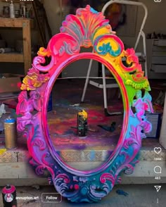 a colorful mirror sitting on top of a table next to paint cans and other items