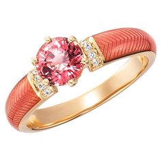 an orange and pink ring with two diamonds on the side, set in yellow gold