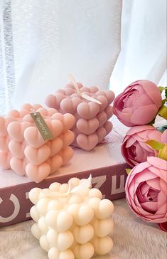 some pink and white balloons sitting on top of a box with flowers in the background