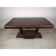 an art deco dining table with two pedestals on each side and a rectangular wooden top