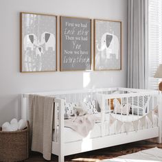 a baby's room with two framed pictures on the wall and a crib