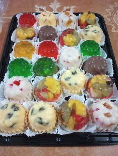 a tray filled with lots of different flavored pastries on top of a table