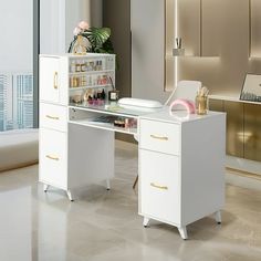 a white desk with gold handles and drawers in a room next to a large window