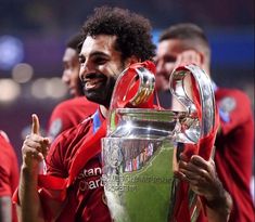 the liverpool united players are celebrating with the trophy