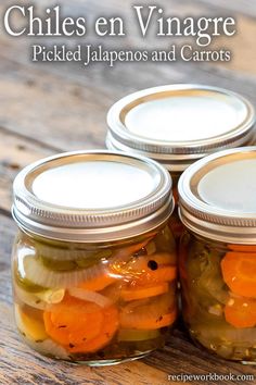 three jars filled with pickled jalapenos and carrots on top of a wooden table