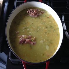 a pot filled with soup sitting on top of an oven