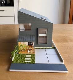 a model house sitting on top of a wooden table