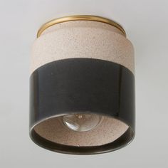 a black and white light fixture with a gold ring around it's center piece