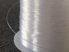 a spool of white thread sitting on top of a table