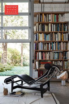 a chair sitting in front of a bookshelf filled with lots of book shelves