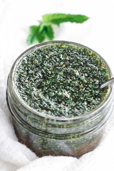 a jar filled with green stuff sitting on top of a white towel