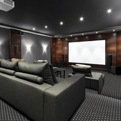 a large living room with couches, chairs and a projector screen