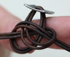 a person is holding a piece of wire in their left hand and the other end has a ring on it