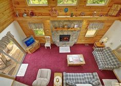 an aerial view of a living room with couches, chairs and a fire place