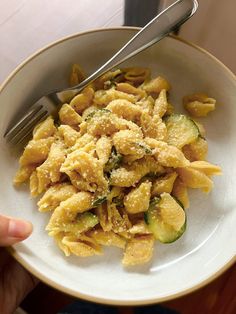 a white bowl filled with pasta and zucchini