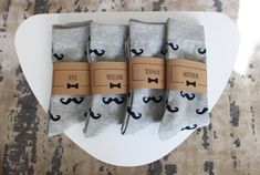 three pairs of socks with mustaches on them are sitting on a white table top