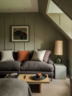 a living room filled with furniture and a painting on the wall next to a window