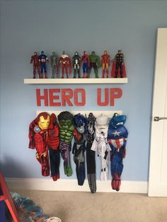 there are many toys on the shelves in this boys'room, including iron man and captain america shirts