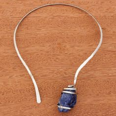 This necklace captures the beautiful deep blue hue of the ocean's depths. Artisan Bruno Walter of Brazil hand crafts this collar necklace out of a ribbon of stainless steel that arcs around the neck and then cradles a freeform nugget of blue sodalite. Steel Collar, Stainless Steel Collar, Ocean Depth, Hand Crafts, Blue Sodalite, Blue Hues, Collar Necklace, Wire Wrapped Jewelry, Deep Blue