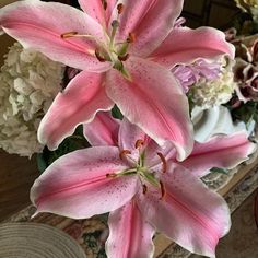 some pink flowers are in a vase on a table