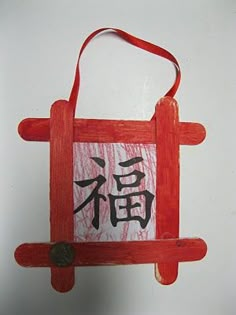 a red bag with writing on it hanging from a hook in front of a white wall